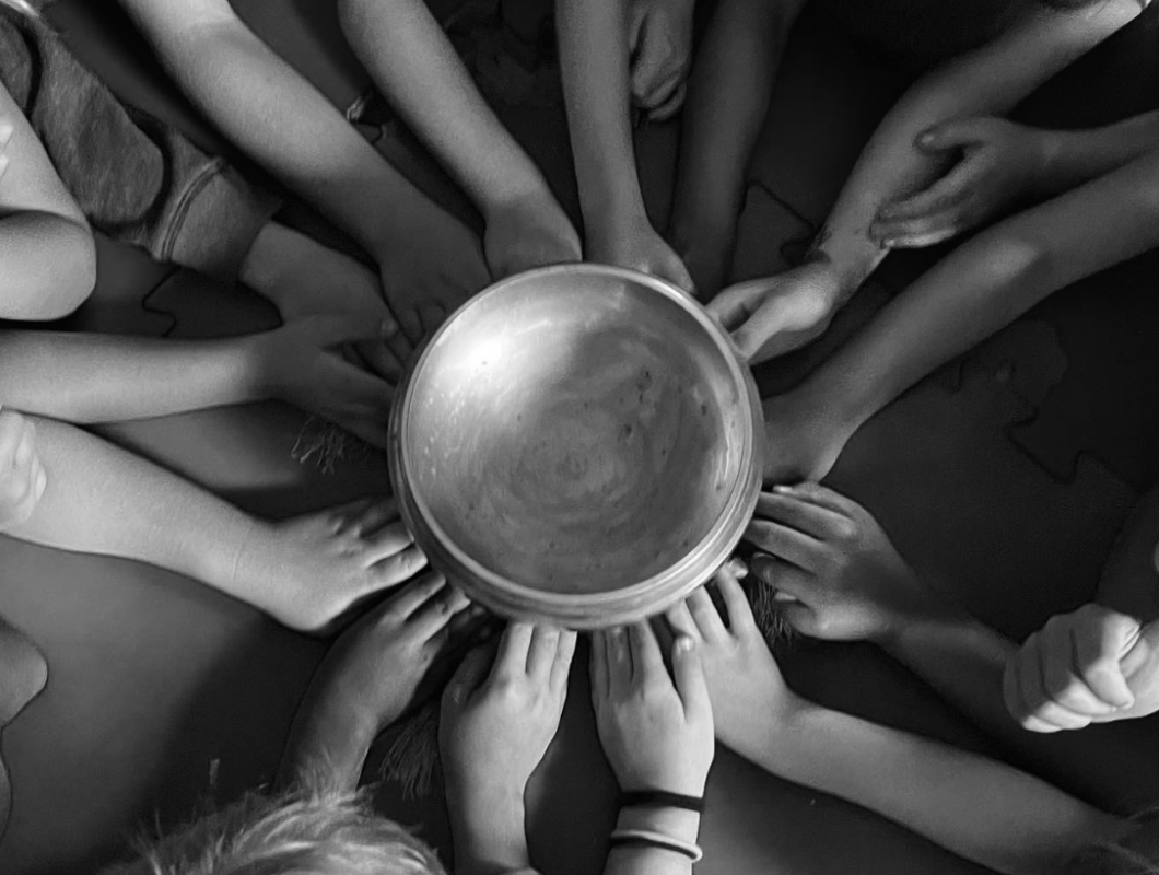 Children gathered around a singing bowl during kids yoga